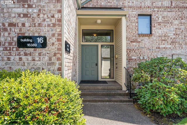 property entrance featuring brick siding