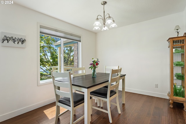 dining area featuring baseboards, dark wood-style floors, and a notable chandelier