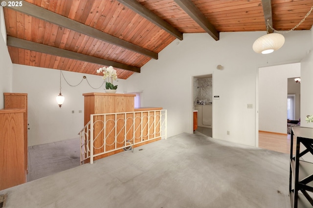 carpeted spare room featuring lofted ceiling with beams, washer / clothes dryer, and wood ceiling