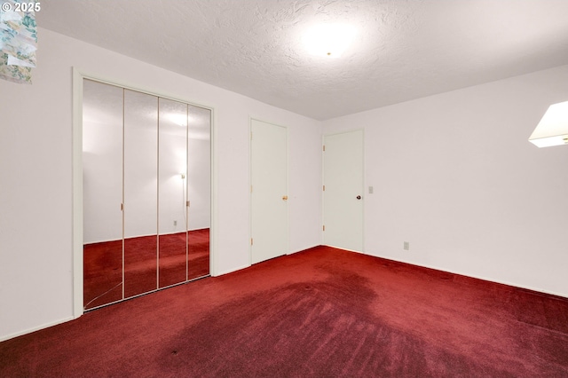 unfurnished bedroom featuring a textured ceiling and carpet flooring