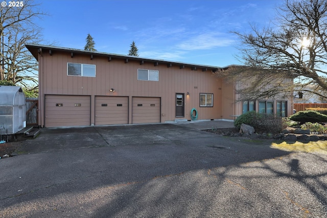 view of front of house with a garage and fence