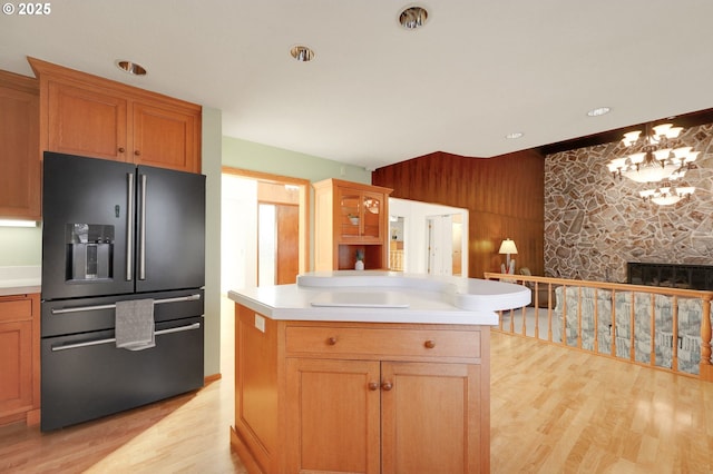 kitchen with light wood-style floors, a notable chandelier, light countertops, and high end black fridge