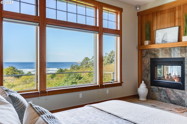 bedroom with a water view and a fireplace