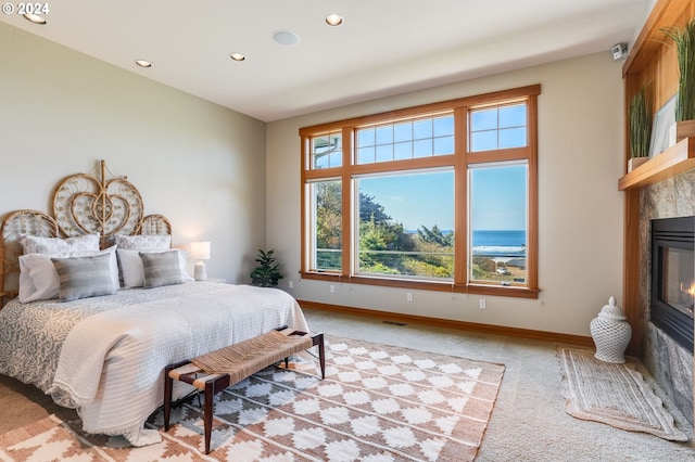 bedroom with light carpet and a tile fireplace