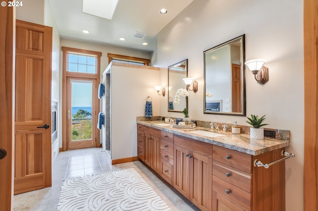 bathroom featuring a healthy amount of sunlight, vanity, a skylight, and tile patterned floors