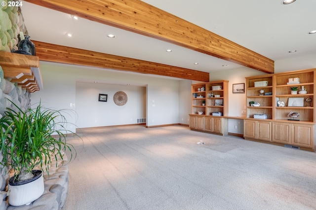 unfurnished living room featuring beam ceiling and carpet flooring