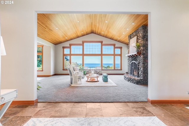 unfurnished living room with wood ceiling, a healthy amount of sunlight, and a stone fireplace