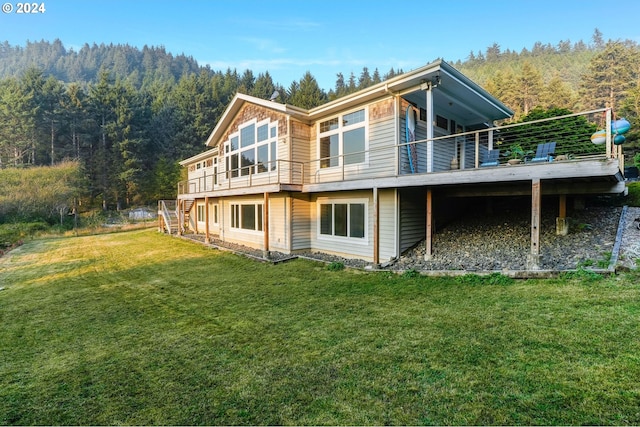 rear view of house with a lawn and a deck