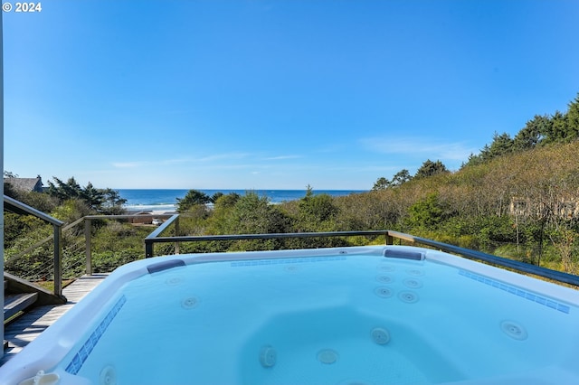 view of pool featuring a water view and a hot tub