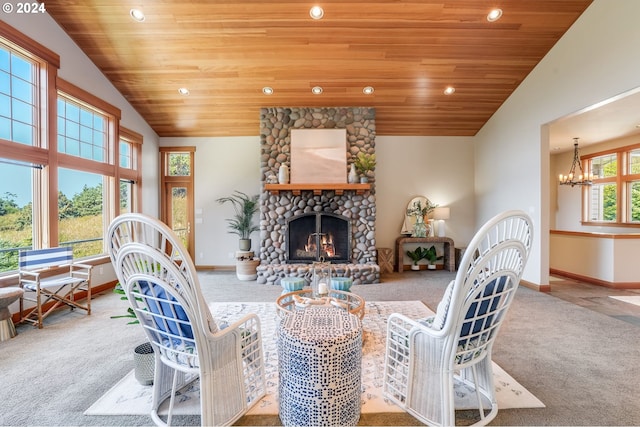 carpeted living room featuring wooden ceiling, a fireplace, high vaulted ceiling, and a notable chandelier