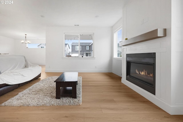 living room featuring light wood-type flooring and a chandelier