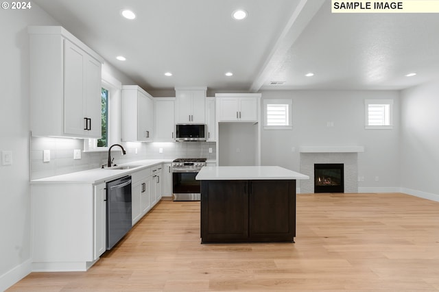 kitchen featuring sink, a center island, white cabinets, and appliances with stainless steel finishes