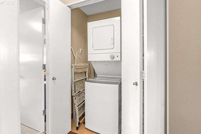 clothes washing area with stacked washer and dryer