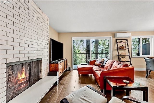 living room featuring a wall mounted air conditioner, plenty of natural light, a fireplace, and dark hardwood / wood-style floors