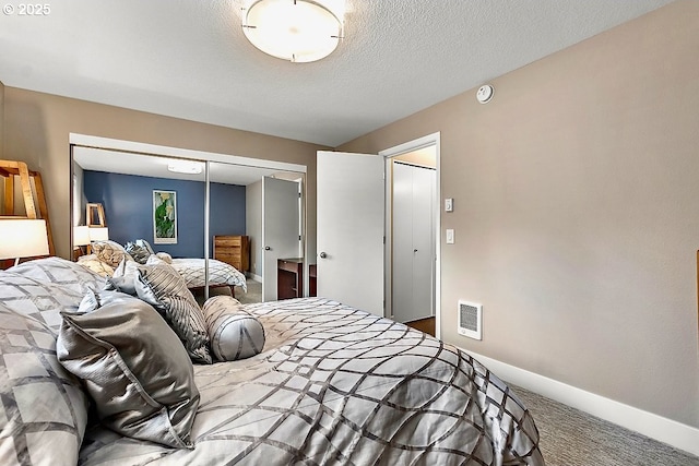 bedroom with a closet, a textured ceiling, and carpet