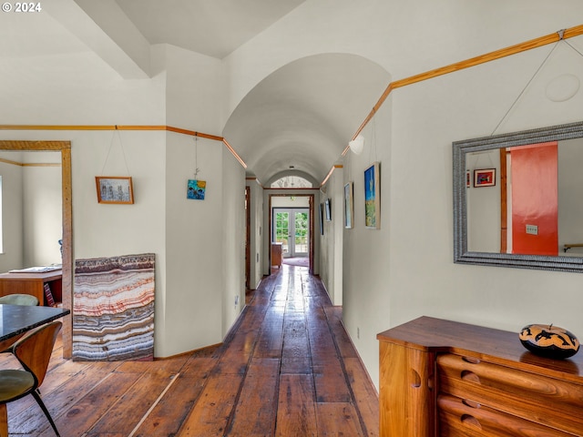 hall with vaulted ceiling and dark wood-type flooring