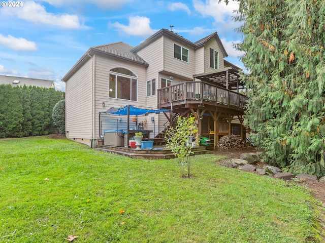 rear view of house featuring a pergola, a deck, and a lawn