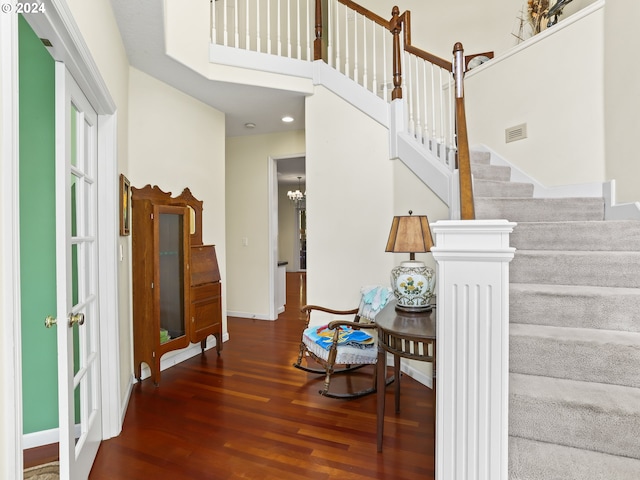 staircase featuring hardwood / wood-style floors and a notable chandelier