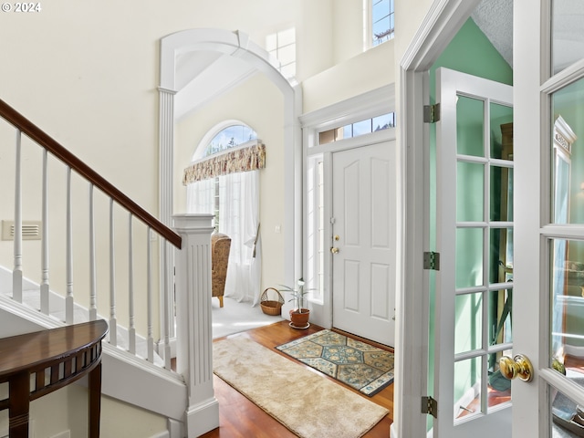 foyer entrance with hardwood / wood-style floors and a high ceiling