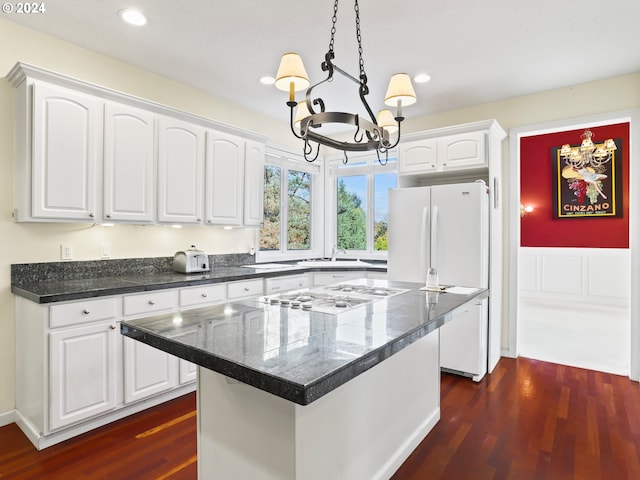 kitchen featuring a center island, white cabinets, hanging light fixtures, and a notable chandelier