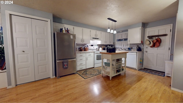 kitchen with white cabinetry, decorative light fixtures, white appliances, and backsplash