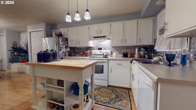 kitchen featuring white appliances, under cabinet range hood, butcher block countertops, white cabinets, and tasteful backsplash