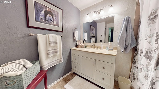 full bathroom featuring a textured wall, vanity, and a shower with shower curtain
