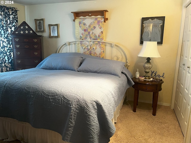 carpeted bedroom featuring a closet and baseboards