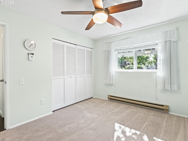 unfurnished bedroom with ceiling fan, a baseboard heating unit, a textured ceiling, light carpet, and a closet