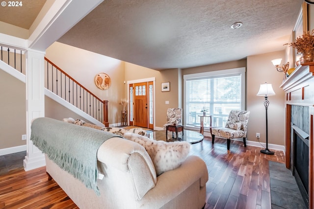 living room with a textured ceiling and dark hardwood / wood-style flooring