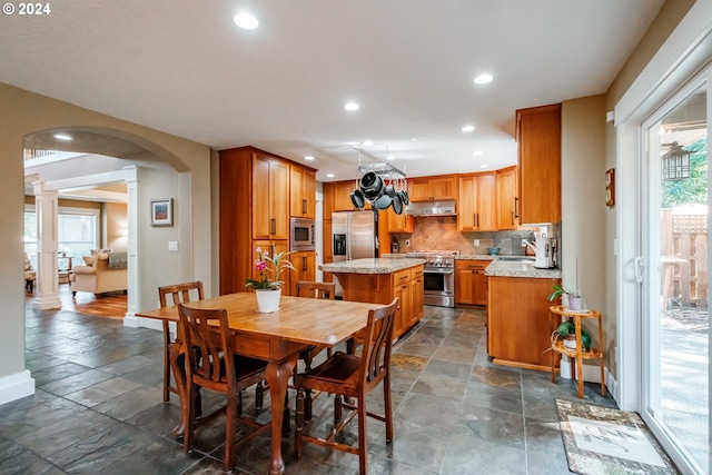 dining area featuring sink and decorative columns