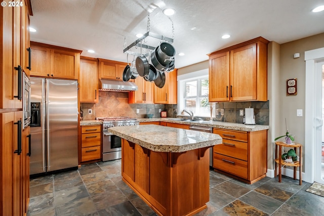 kitchen with a kitchen bar, backsplash, sink, high quality appliances, and a kitchen island