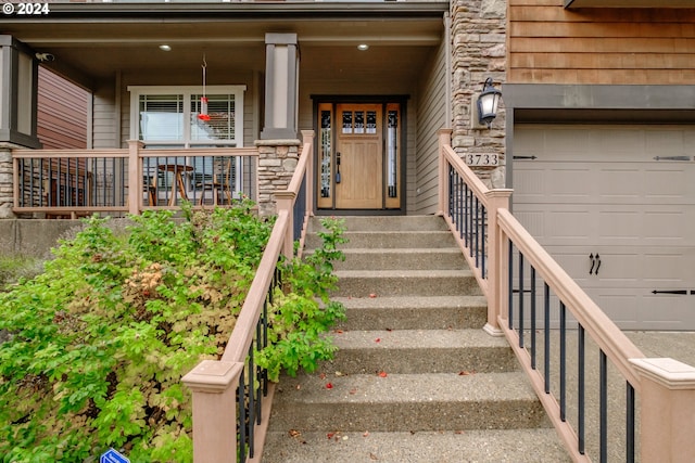 doorway to property featuring a porch and a garage