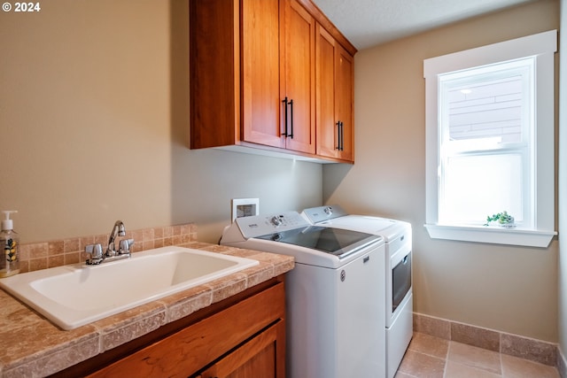 laundry area with washer and clothes dryer, cabinets, and sink