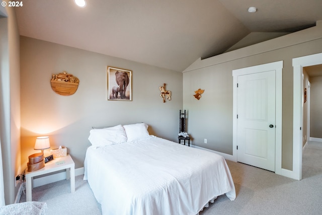 bedroom with light colored carpet and lofted ceiling