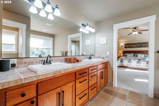 bathroom featuring a textured ceiling, vanity, tile patterned floors, and ceiling fan