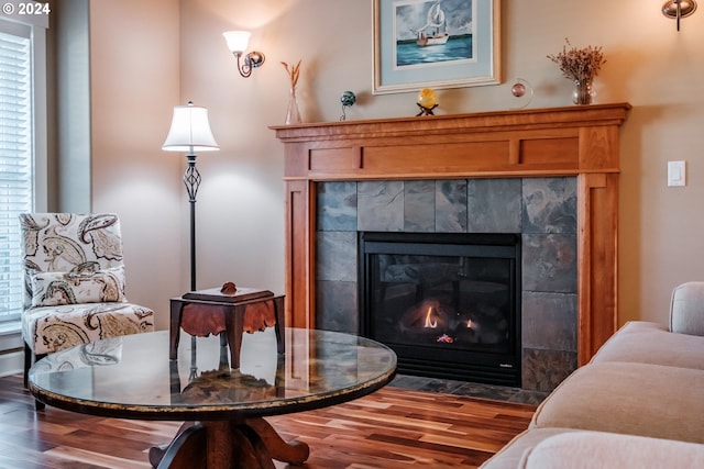 living area featuring a tile fireplace and wood-type flooring