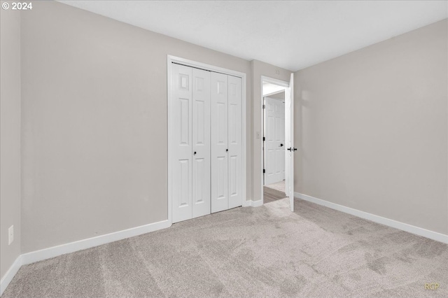 unfurnished bedroom with carpet floors and a closet