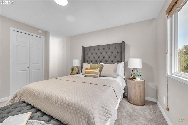 bedroom featuring light colored carpet and a closet