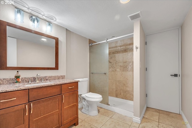 bathroom featuring a textured ceiling, vanity, an enclosed shower, tile patterned floors, and toilet