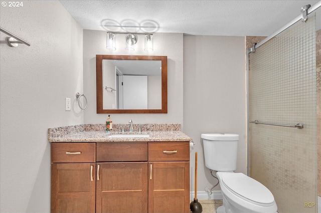 bathroom with vanity, walk in shower, a textured ceiling, and toilet