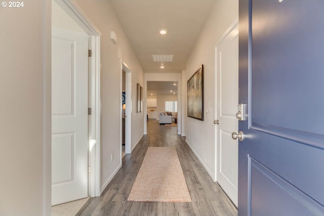 corridor with hardwood / wood-style flooring