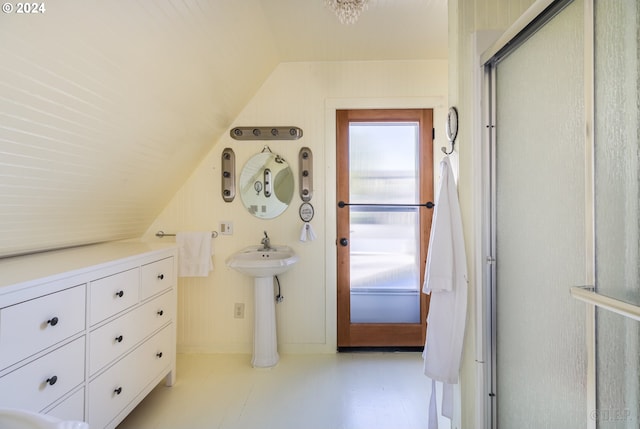 bathroom with walk in shower, sink, and vaulted ceiling