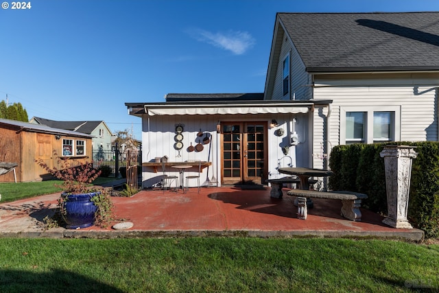 rear view of property featuring french doors, a lawn, and a patio