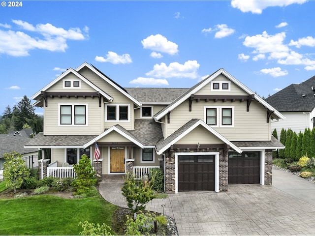 craftsman-style home with a garage, a front yard, and a porch