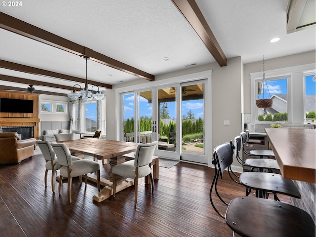 dining space featuring dark hardwood / wood-style floors, beam ceiling, a chandelier, and a textured ceiling