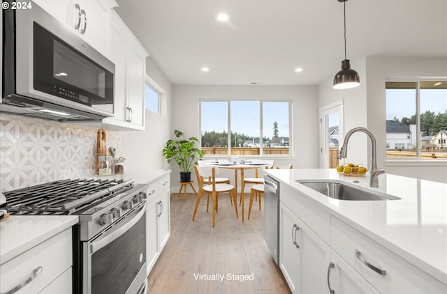 13886 SW Sabrina Ave, Tigard, OR 97140 - kitchen with a sink, light wood-style floors, stainless steel appliances, light countertops, and recessed lighting
