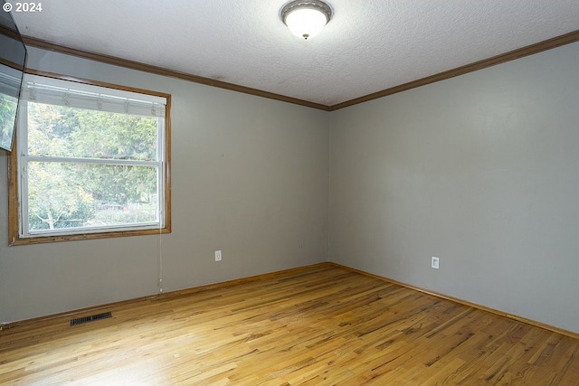 spare room with light hardwood / wood-style flooring, a textured ceiling, and crown molding