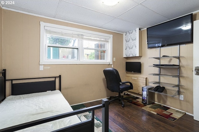 bedroom with dark wood-type flooring and wood walls