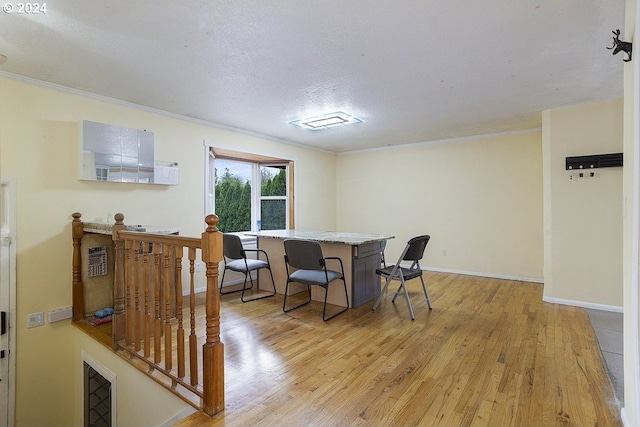dining area with crown molding, baseboards, light wood finished floors, and a textured ceiling